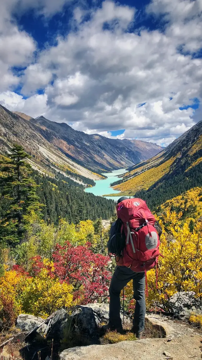徒步者背负行囊俯瞰高山湖泊